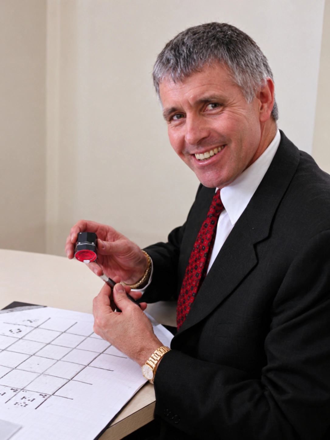 Garry Holloway seated at his desk holding an Ideal-Scope
